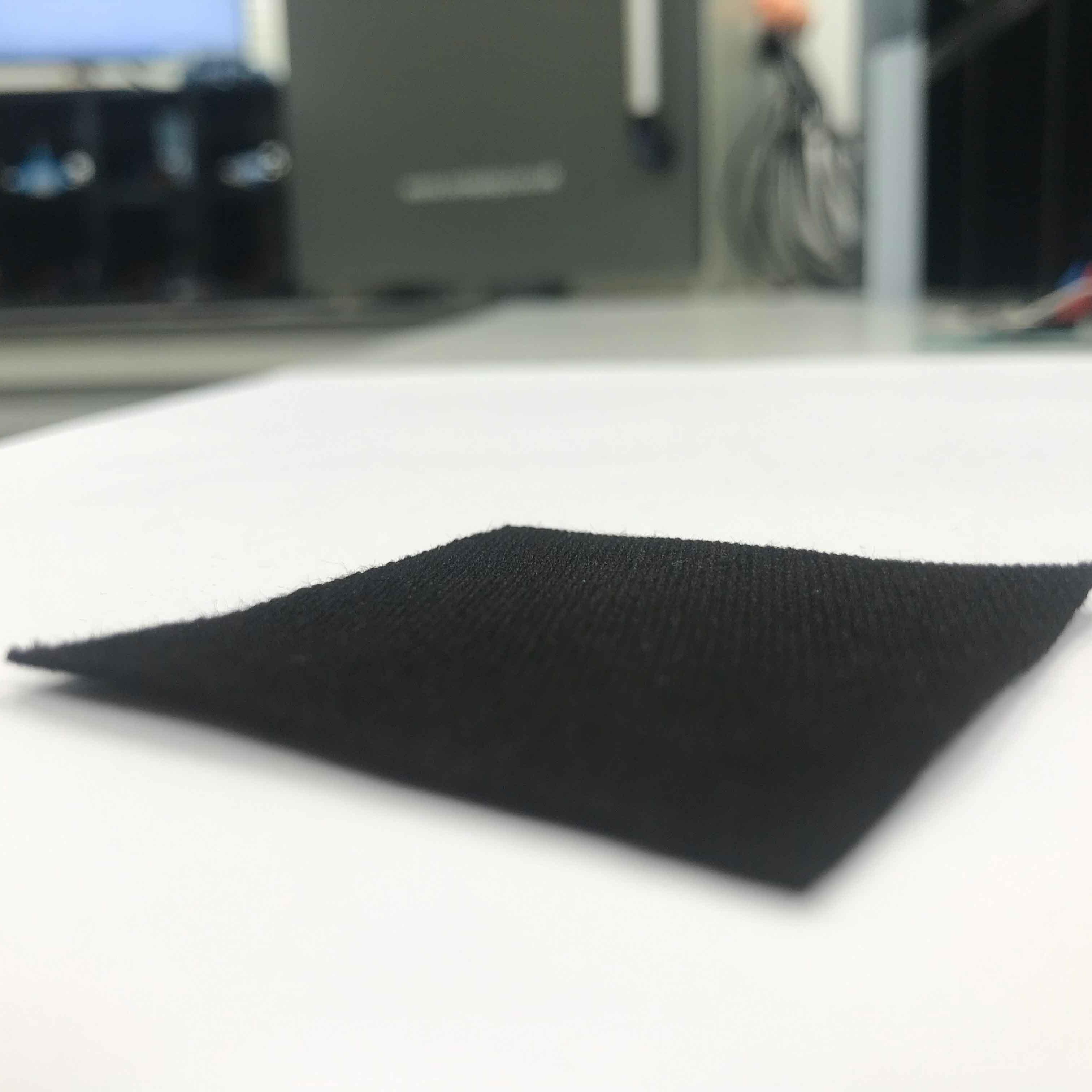 		A square, thin sheet of black carbon on a tabletop
	