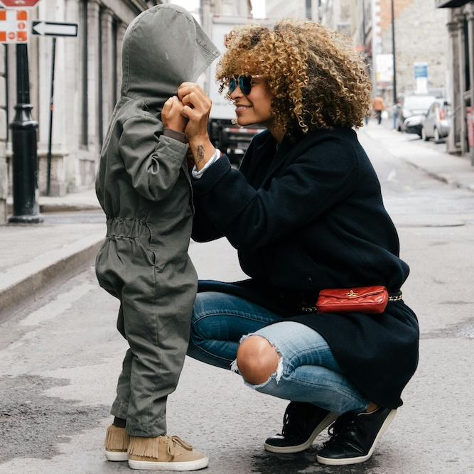		A mother helping a child with the hood of a parka
	
