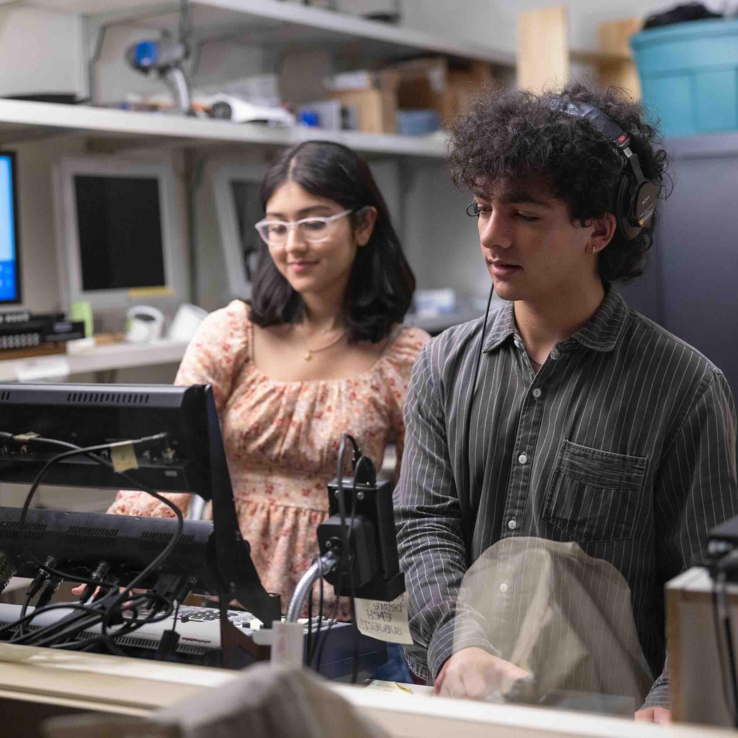 		two people working behind a computer
	