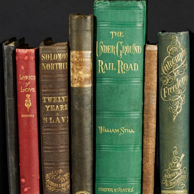 Old-looking books of different heights and colors standing in a row