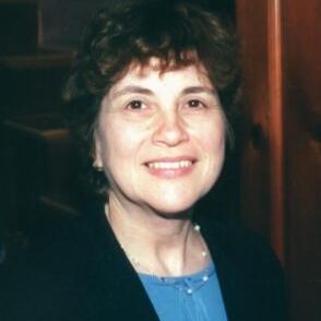 		Deanne Gebell Gitner, smiling, with short black hair, a jacket and pearl necklace
	