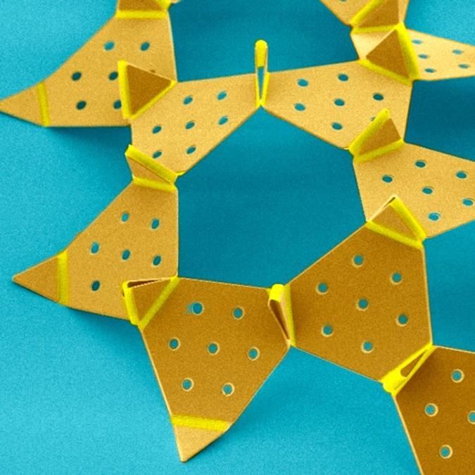 		yello triangles with holes punched in them, all conntected, on a blue background
	