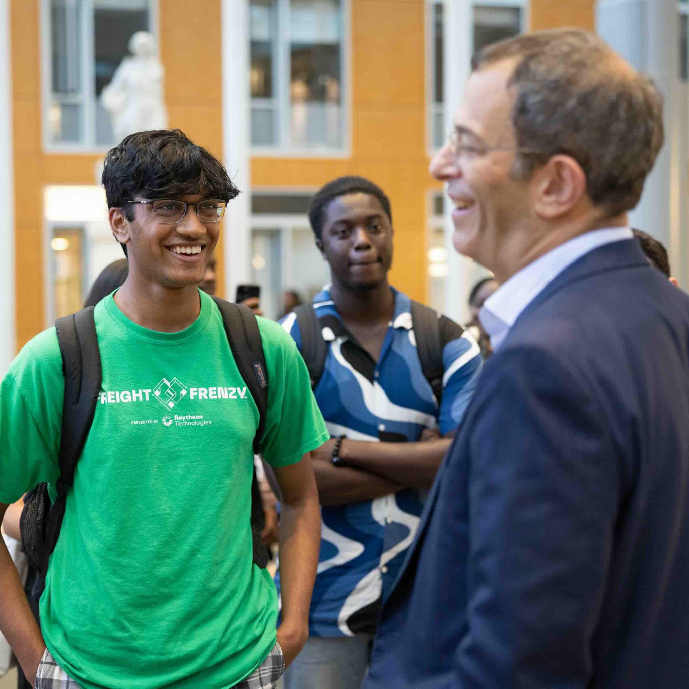 man talking to two students