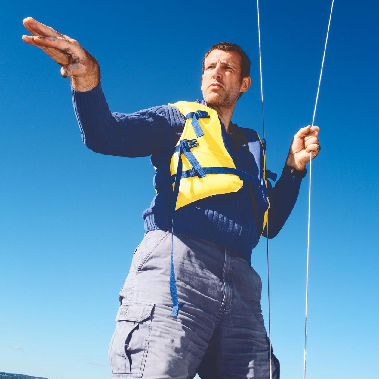 		Person wearing a yellow life jacket, standing up in a boat
	