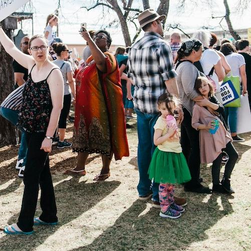 		Dozens of people standing on a lawn, at a public rally
	