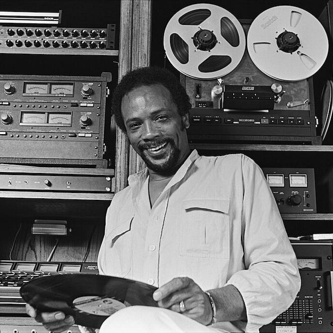 		Person holding an LP in front of recording equipment in a studio
	