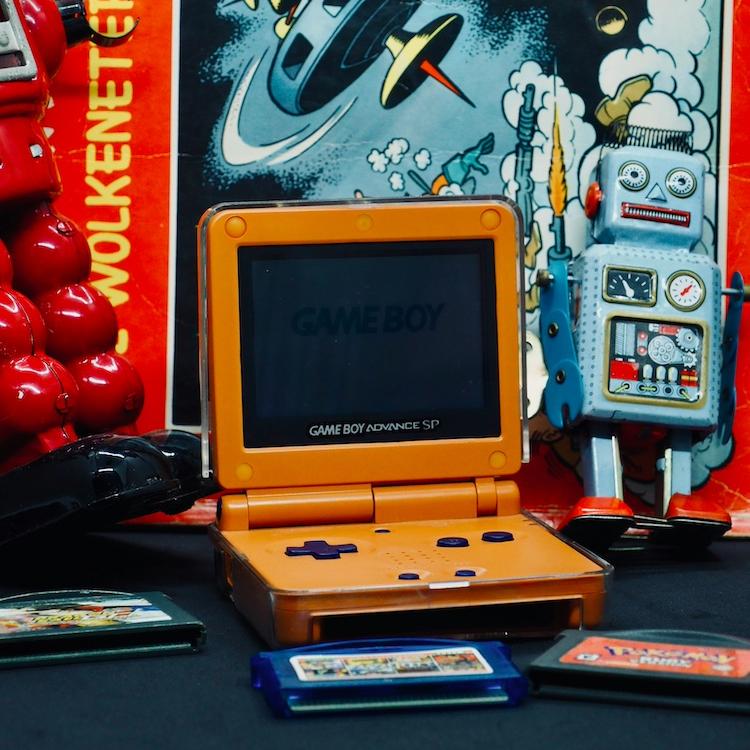 		small orange handheld video game player with a spaceship backdrop
	