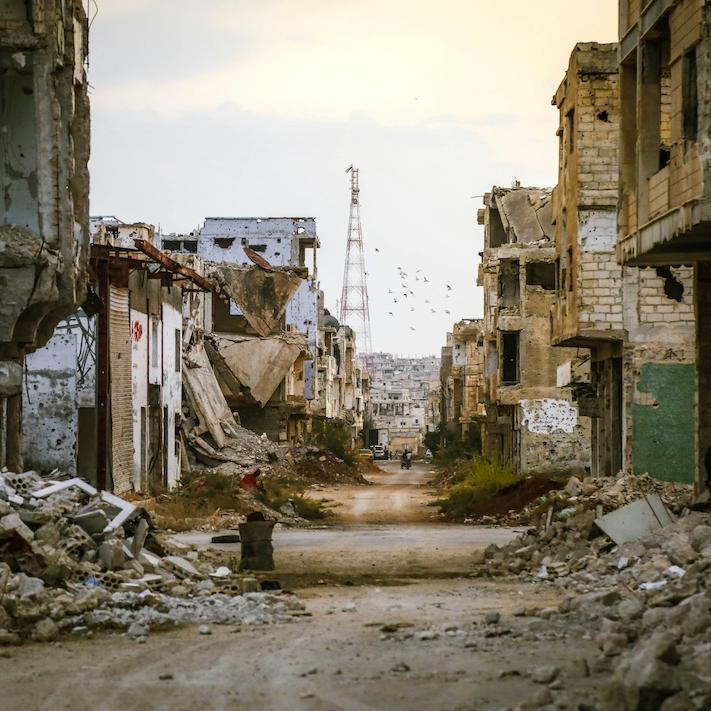 		Looking down a desolate street damaged by war
	