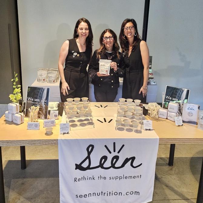 		Three people stand behind a product table for "Seen Nutrition"
	