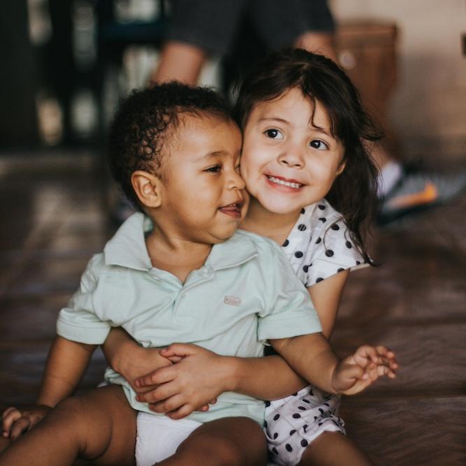 		Two kids sitting on a floor
	