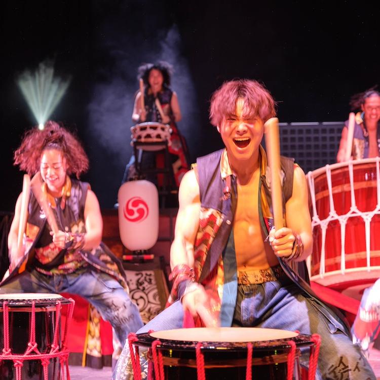 People playing large drums, joyfully