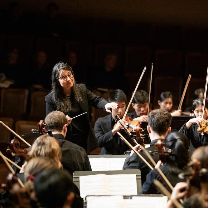 A conductor directs an orchestra