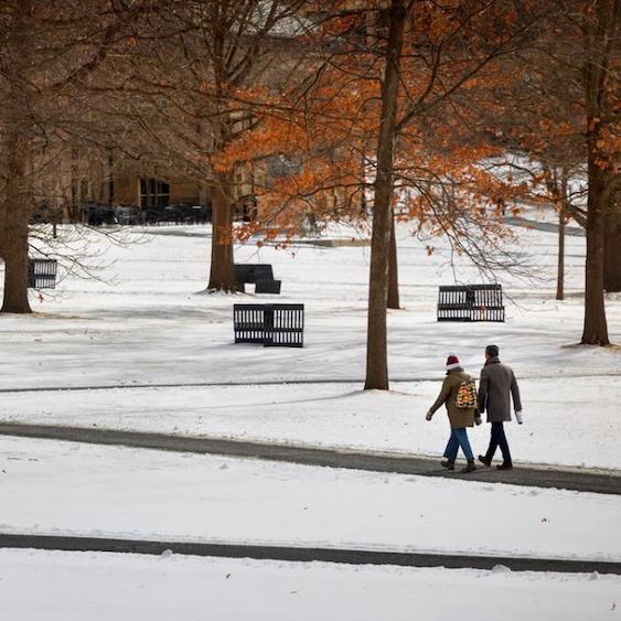 		Two people walk across a snowy college quad
	