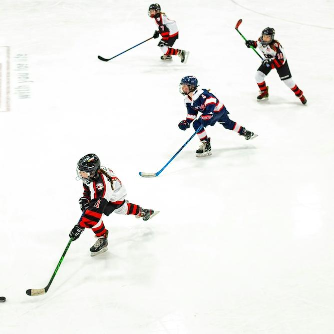 		Four young ice hockey players, skating
	