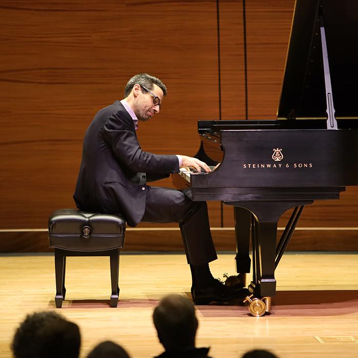 		Person sitting at a grand piano, playing thoughtfully
	