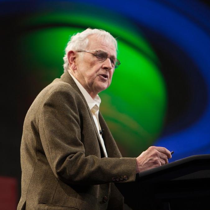 		Person speaking at a podium with an image of a planet in the background
	