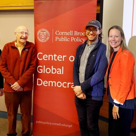 Five people stand near a sign that says "Center on Global Democracy"