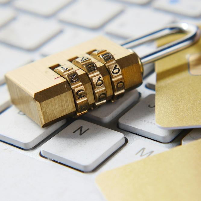 A gold padlock on a white computer keyboard