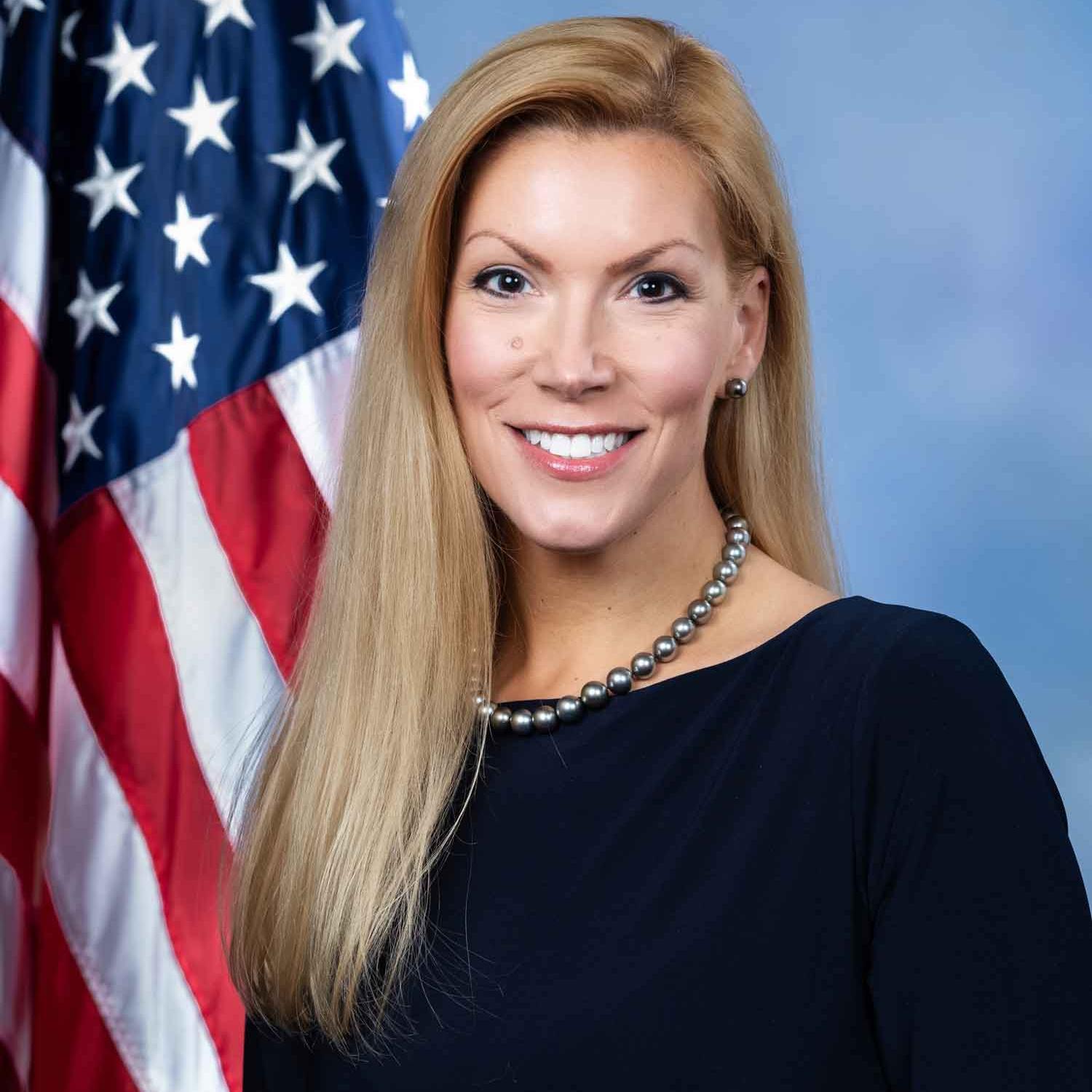 person smiling by American flag