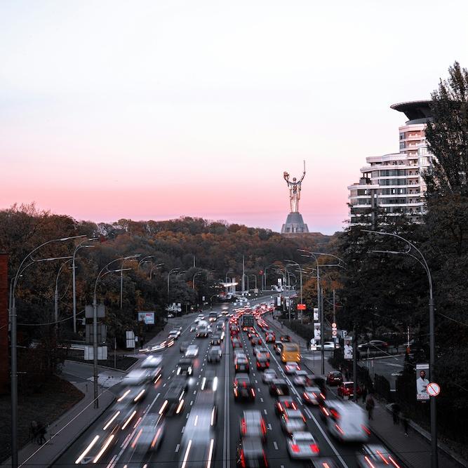Cars speed down a six-lane road through a city
