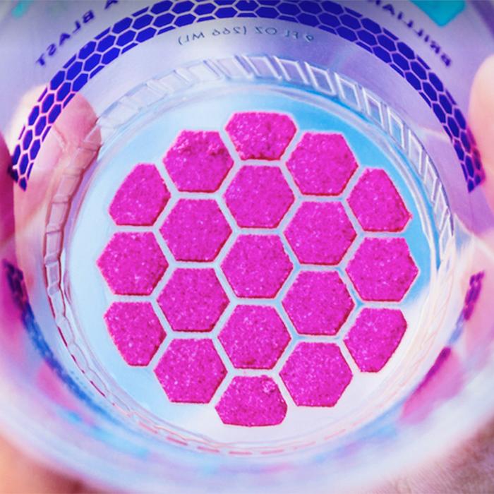 Looking closely at the inside of a plastic cup that has a circle of fuscia hexagons stuck to the bottom 