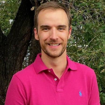 Brad Ramshaw, smiling, with very short mustache and beard, in a polo shirt in front of a tree