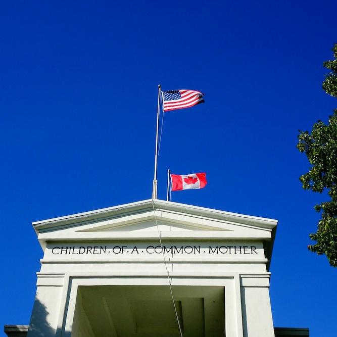 White stone building with two flags flying over it