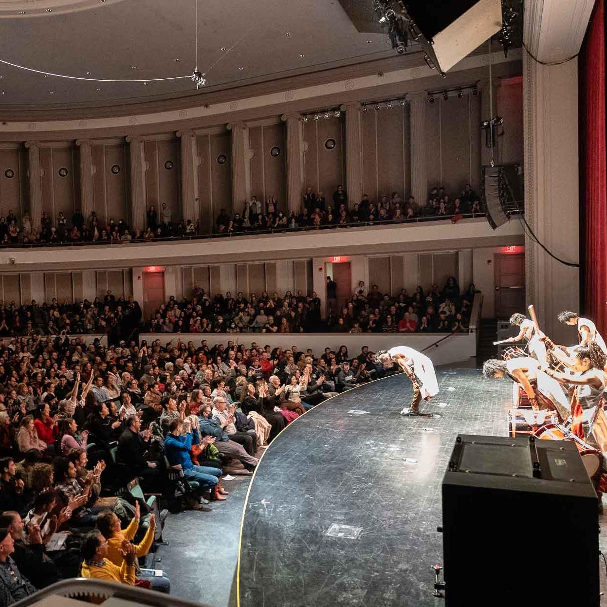 		people on a stage taking a bow
	