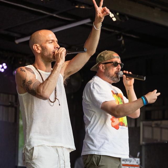three people singing from a stage
