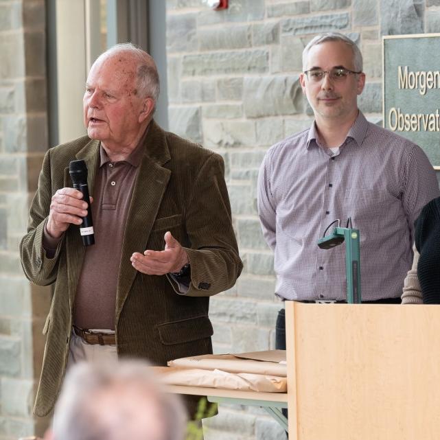 		Person speaks, holding a microphone
	