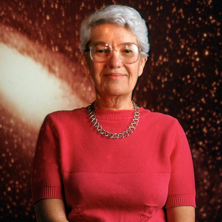 		Person wearing red sits for a portait, backed by an image of a galaxy
	