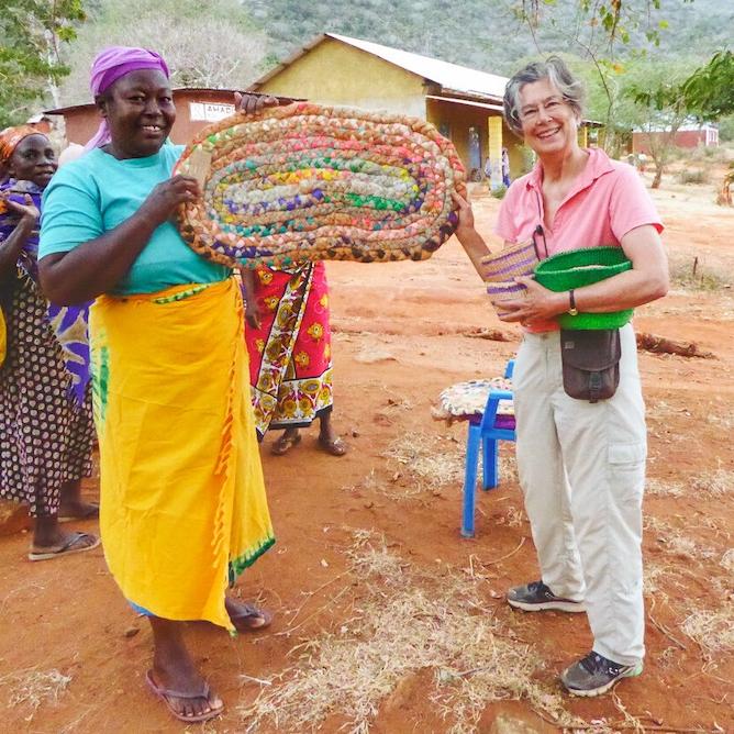 Two people holding a large, colorful basket between them