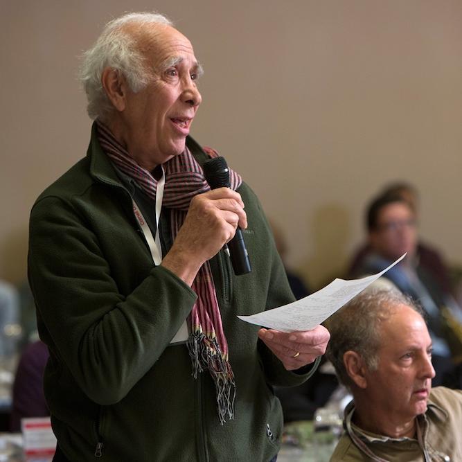 		Person holding a piece of paper and speaking into a microphone
	