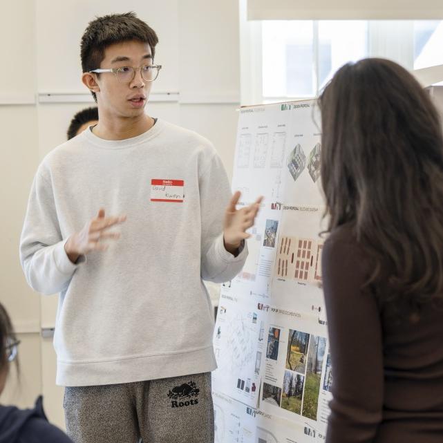 People giving a presentation with a poster