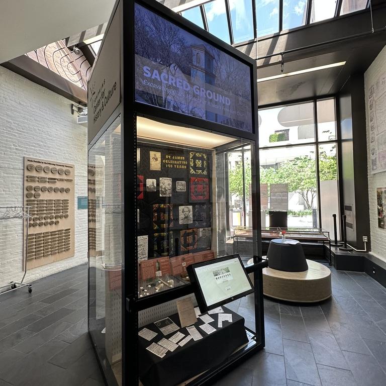 Tall display case in a museum room that's full of light