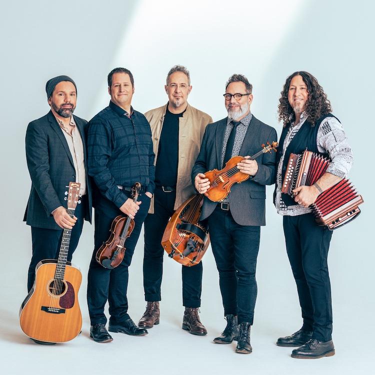 Five musicians hold folk instruments in a publicity portrait