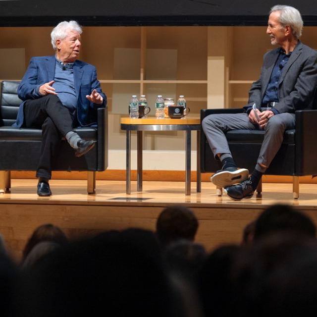 Two people conversing on a stage during an event