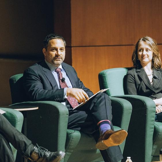 Three people sitting in arm chairs during an on-stage event