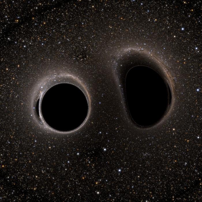 		two black holes approach each other with a dark background of space
	