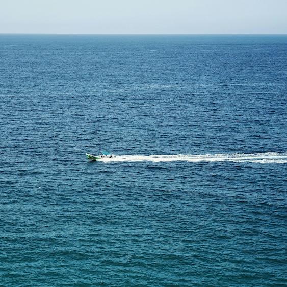		small boat traveling over open water
	