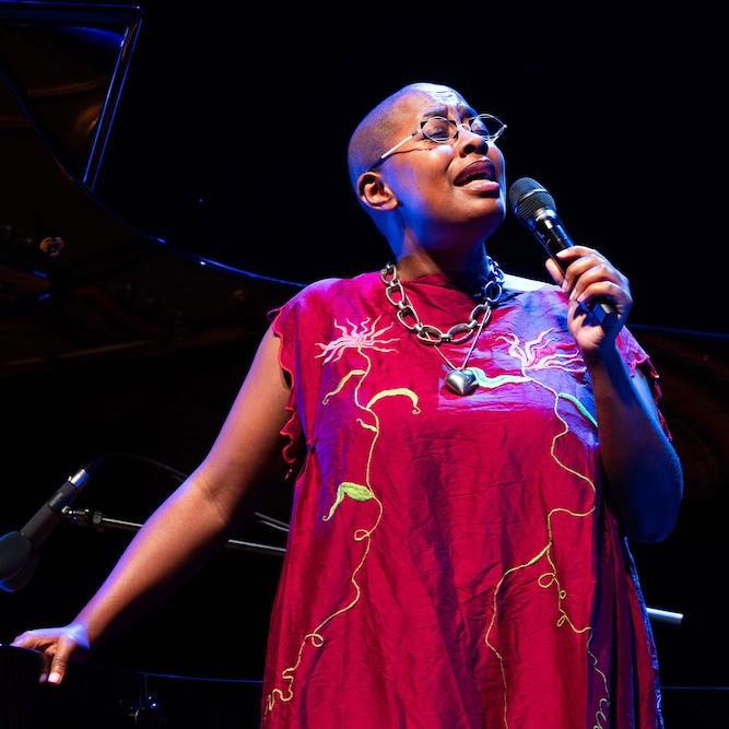 		Person in a red dress, singing into a microphone
	
