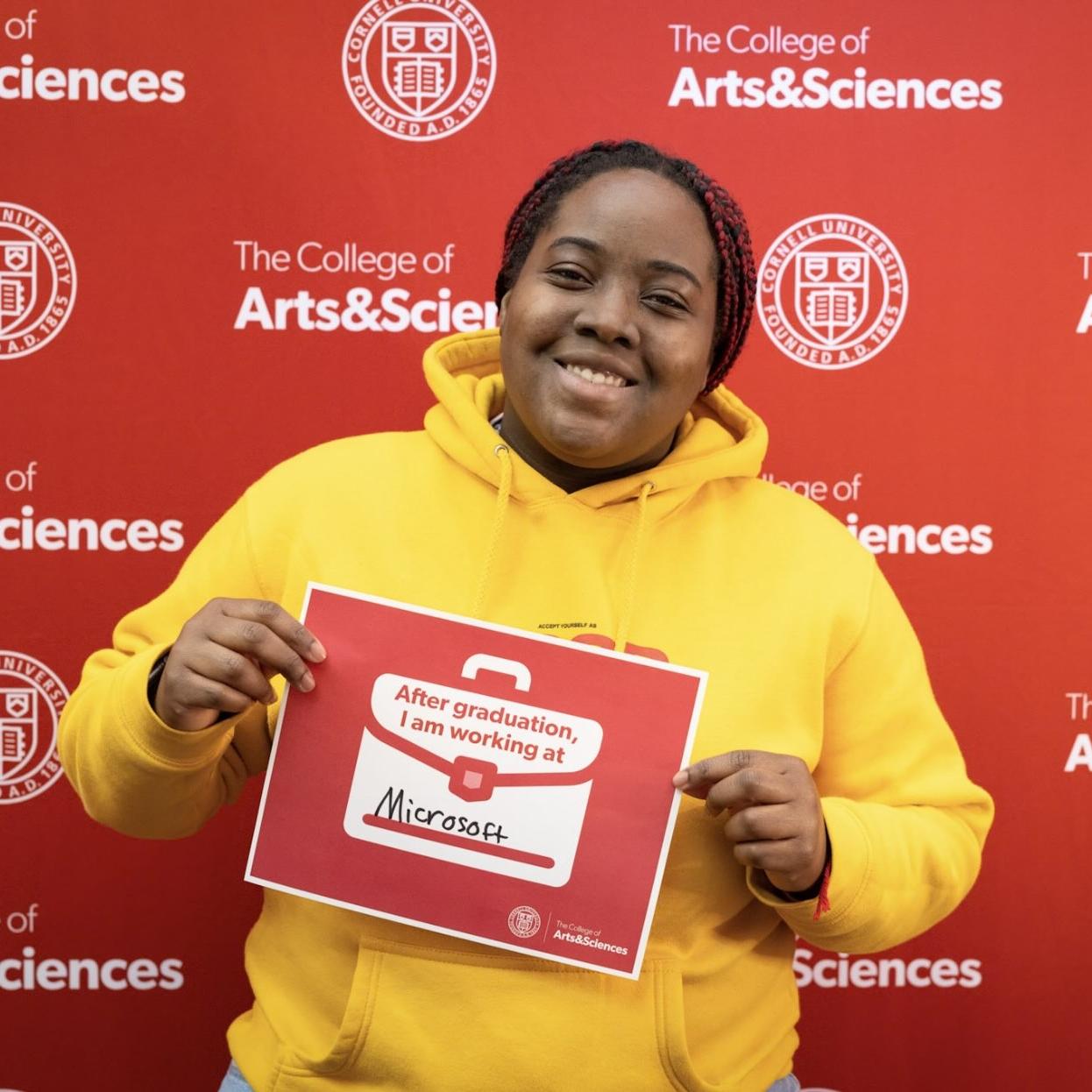 person holding sign saying they are working for Microsoft
