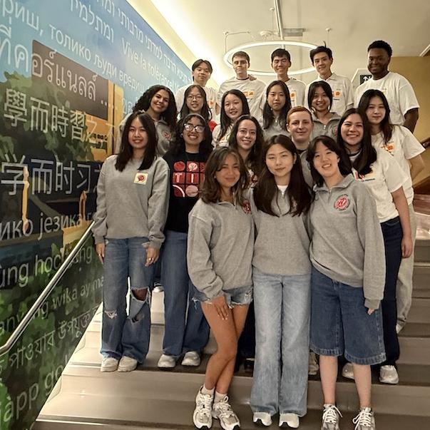 About 20 people pose as a group on a staircase. 