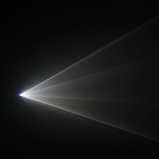 		Light source sends white rays across a dark space
	