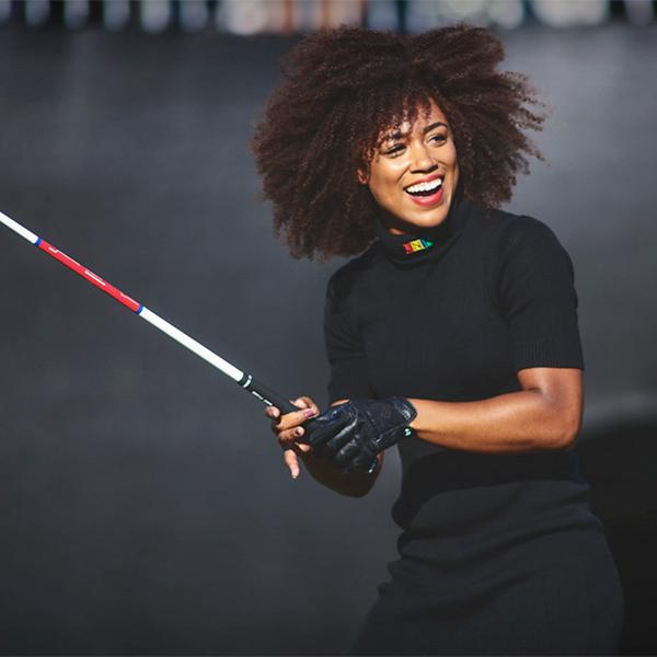 		Person holding a golf club casually, smiling
	