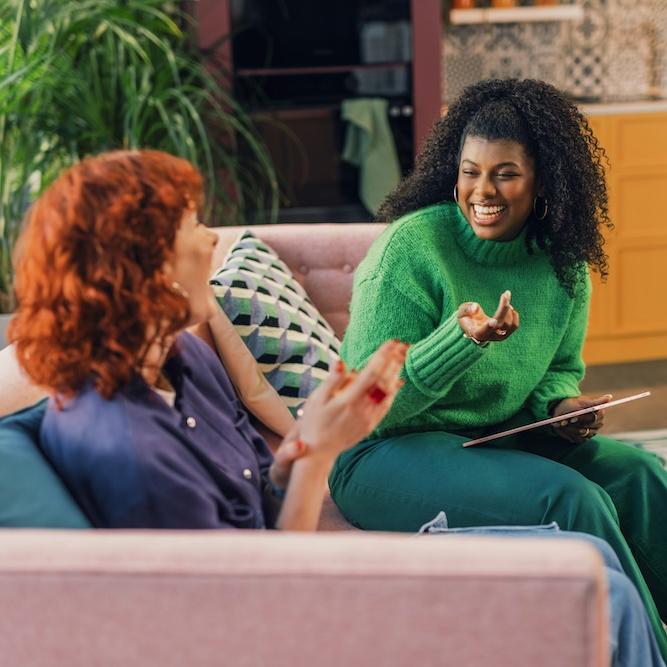 		Two people sitting on a couch, conversing
	