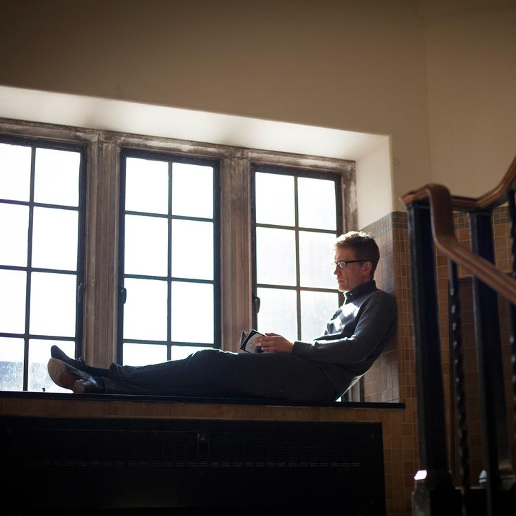 		Person sitting in a deep windowsill, reading a book
	