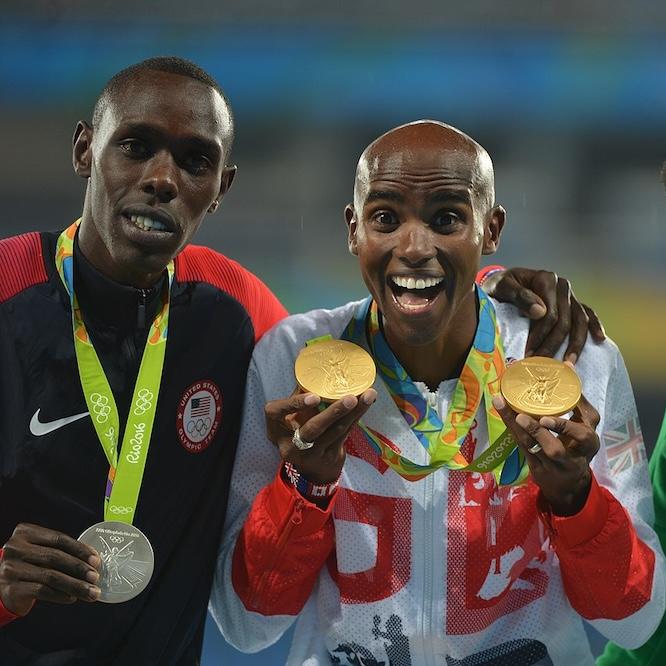 Three people holding up medals they've just won