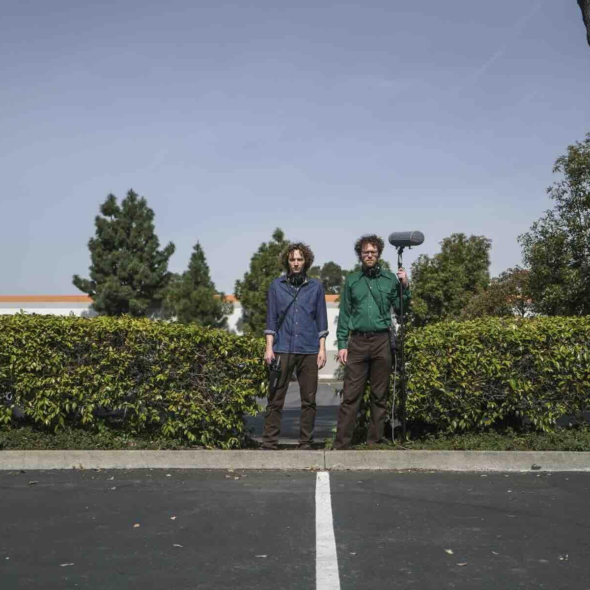 two people with microphone standing outside