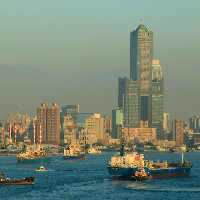 City skyline with a waterway in the foreground, filled with boats